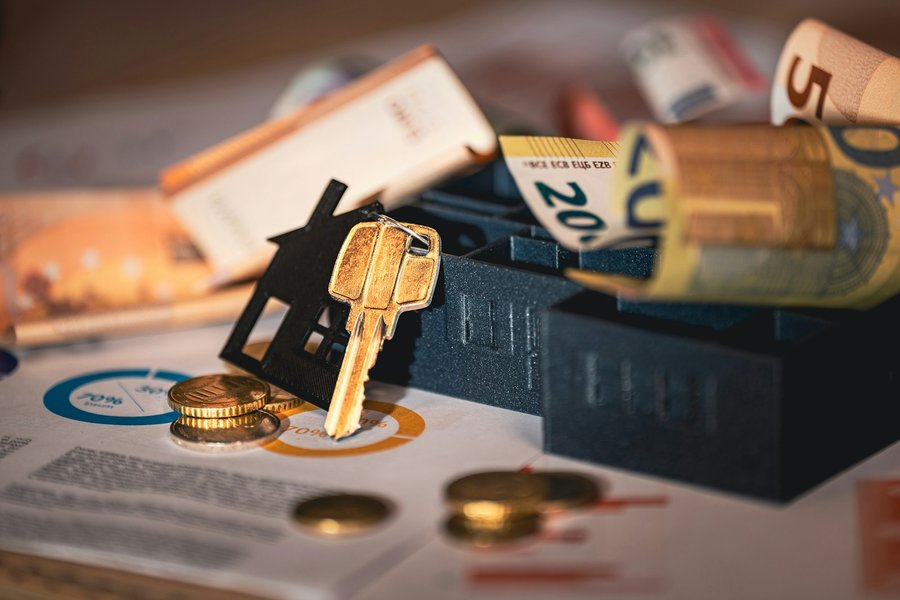 Chave em forma de casa sobre notas de euro e documentos de crédito